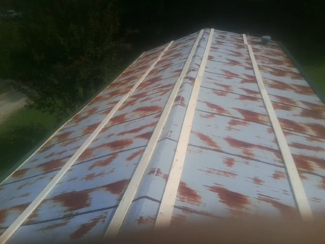Rusted metal roof panels with new wood purlins before replacement — Storm Damage Roof Repair in Urbandale by Roofing Brothers
