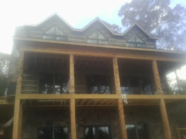 Dormers and porch framing on a large log home under construction — Roof Coating work by our crew in Urbandale