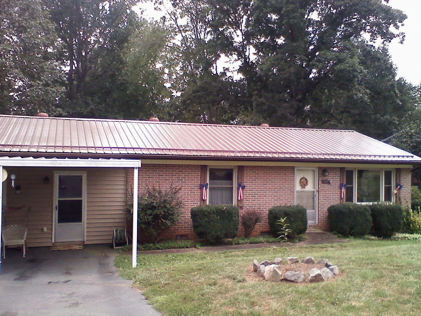 Bronze metal roof and carport on a brick ranch home — Roof Repair work by our crew in Urbandale